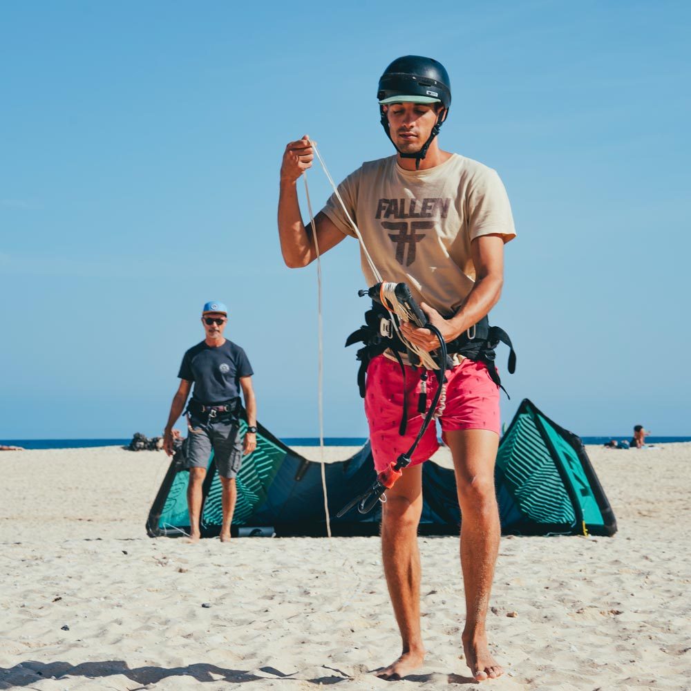 Alumno de nivel intermedio preparando la cometa en la playa