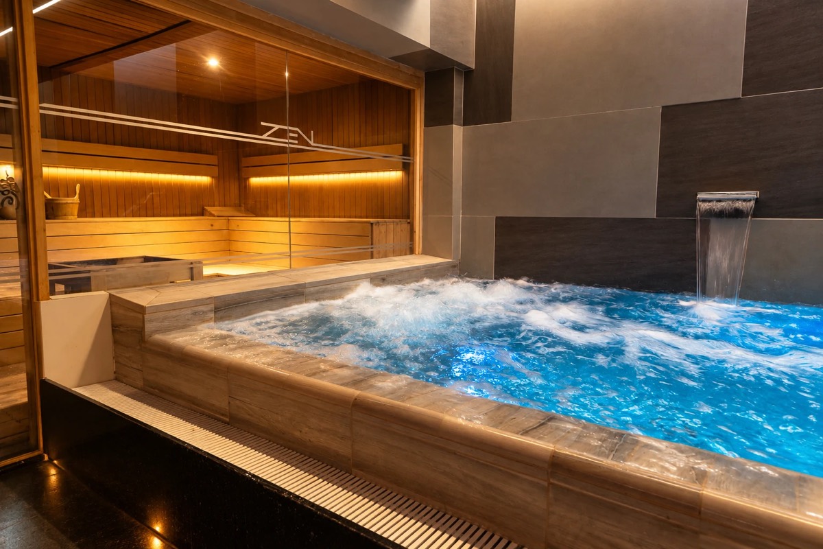 Piscina de hidroterapia con cascada junto a la sauna del spa
