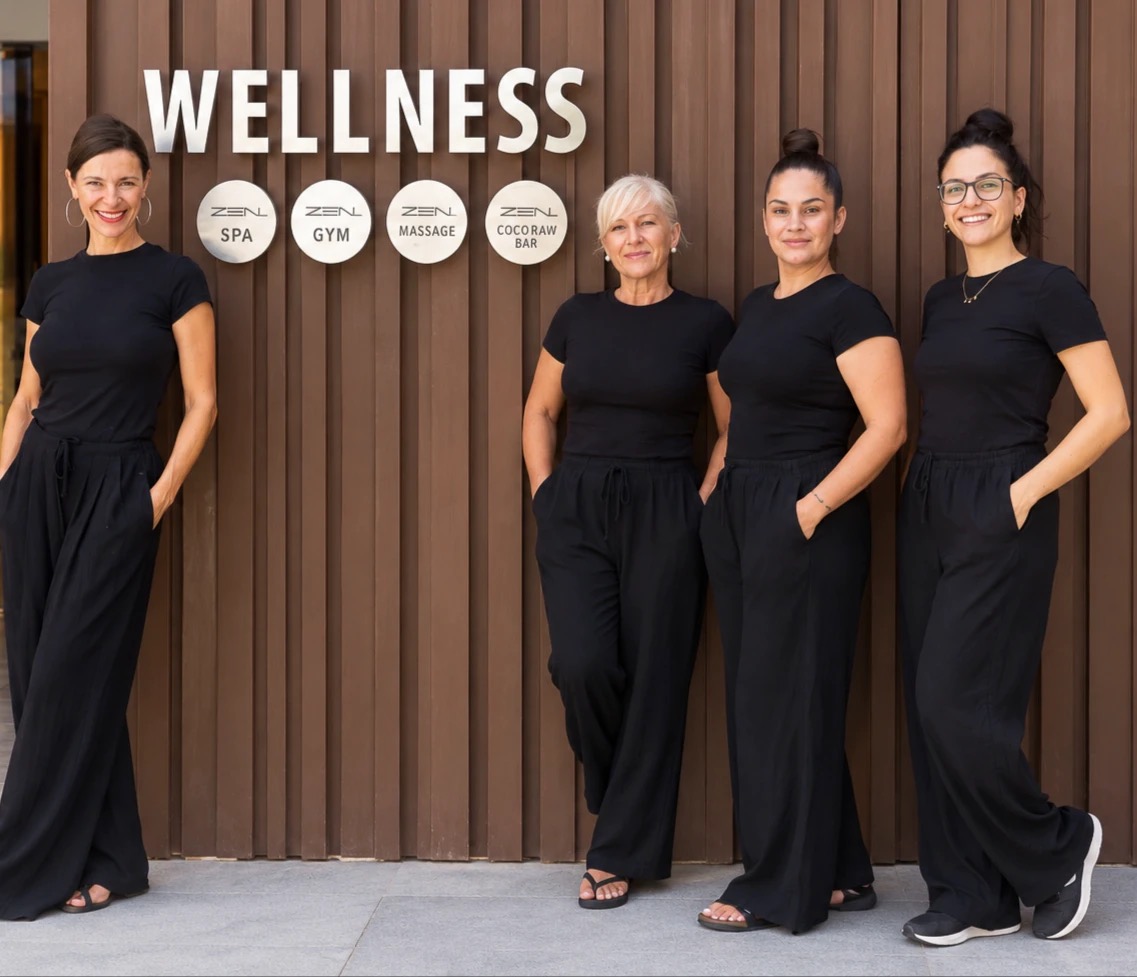 Las terapeutas de SpaZensation frente al cartel Wellness del hotel