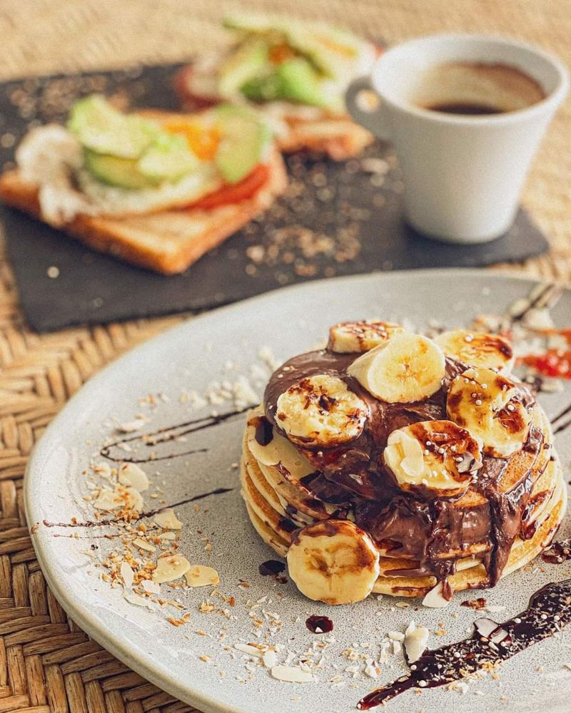 Pancakes con plátano y chocolate, tostada y café del brunch